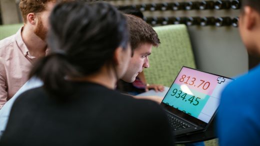 A group of people looking at a magnified computer screen